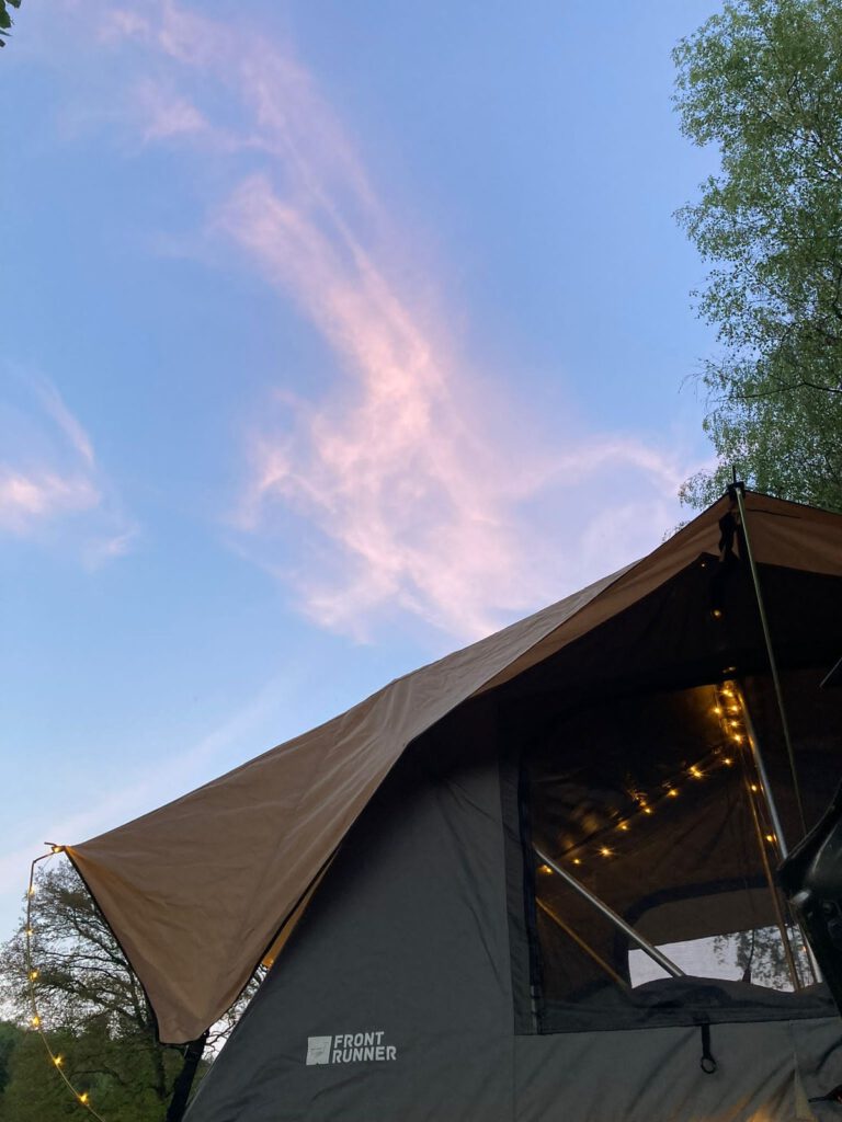 Front Runner Feather-Lite mit Lichterkette am Vordach und einer Campinglampe an der Leiter